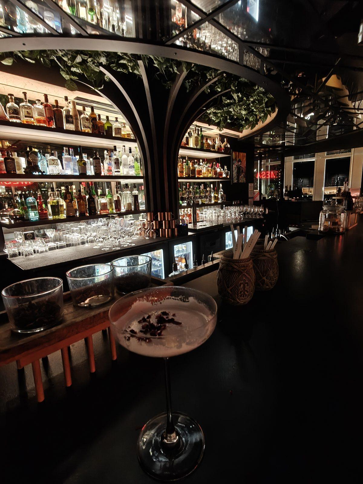 Bar du Mesa Lille de nuit, mur de bouteilles et cocktail servi au comptoir